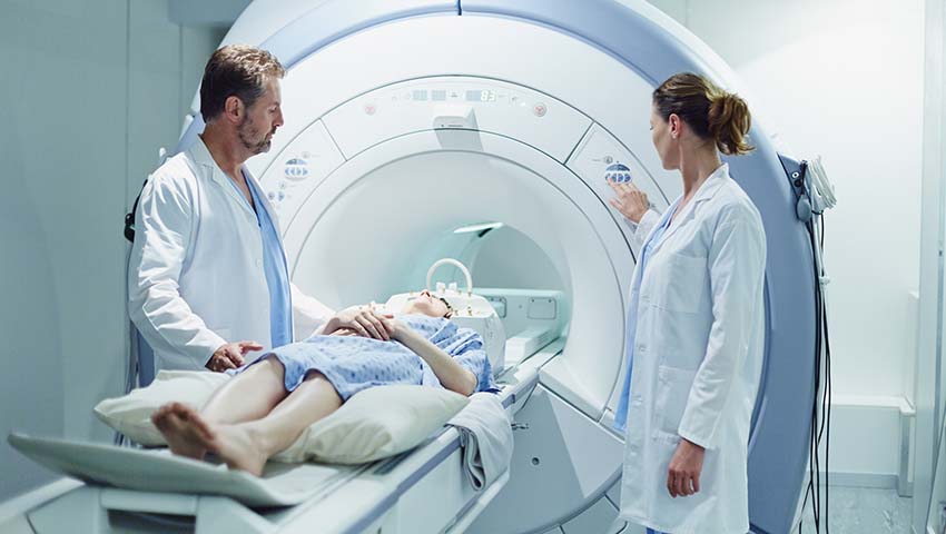 Doctors preparing patient for MRI scan